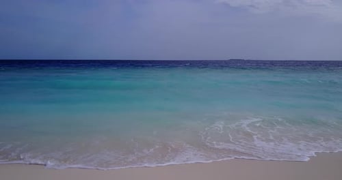 Beautiful fly over island view of a white sand paradise beach and aqua blue ocean background in colo