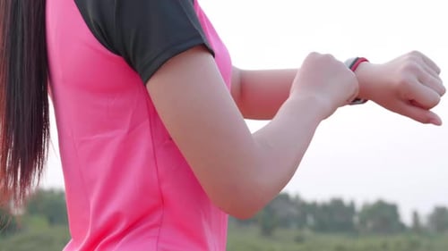 Close up young sport Asian woman setting smartwatch before running outdoor exercise