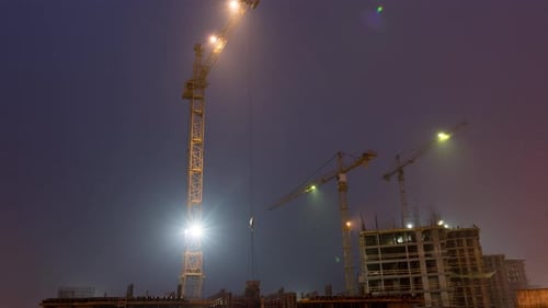Construction site with crane night time lapse. Building of skyscrapers.