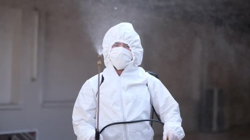 Arbeiter in einem Schutzanzug desinfiziert Oberflächen vor Coronavirus. Antibakterielle Gesundheitsmaßnahmen auf