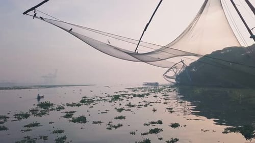 Traditional Chinese fishing nets at sunrise, Fort Kochi, India. Low aerial drone Traditional Chinese fishing nets at sunrise, Fort Kochi, India. Low aerial drone