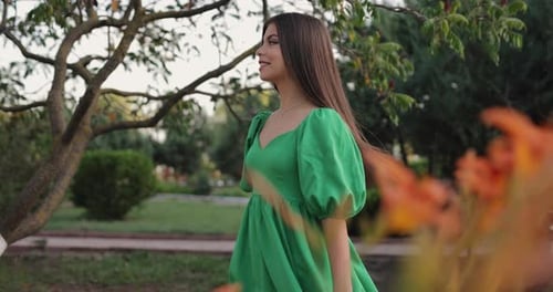 Beautiful Woman Walking in a Park in the Dress