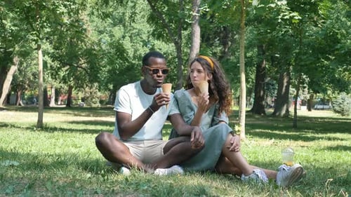 Young Couple Enjoying Ice Cream in the Park