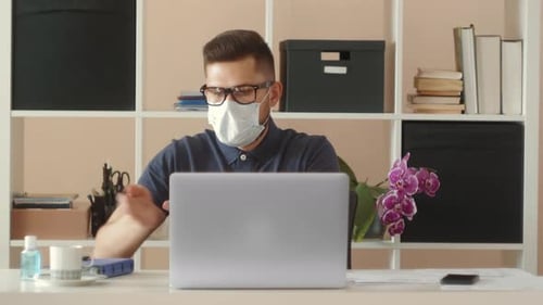 Adult Typing on Laptop with Mask and Sanitizer