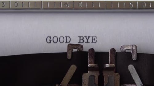 Typing phrase GOOD BYE on retro typewriter. Close up.