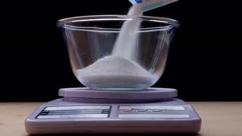 Sugar Being Poured into a Bowl on a Scale
