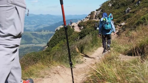 Gruppe von Touristen und Kindern mit Rucksäcken geht auf Stone Trail in Mountain