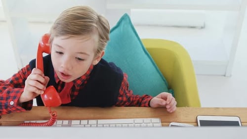 Boy at Desk with Old-Fashioned Telephone
