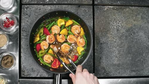 Cook Flipping Shrimps Frying in Pan