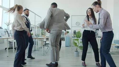 Cheerful Young People Men and Women Enjoying Dance Celebrating Company Achievement in Office