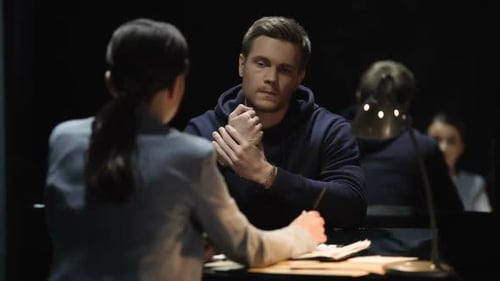 Man in Handcuffs Being Questioned by Officer