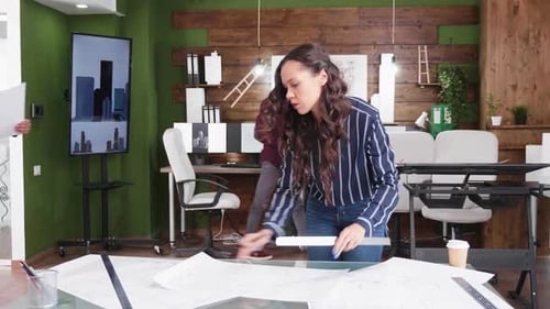 Young Architect Arriving at the Office with Blueprints