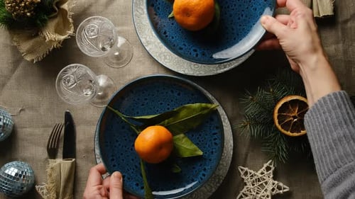Setting Holiday Table with Tangerines and Festive Decorations