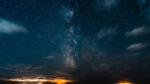 Milchstraße mit Sternen und Galaxien am Nachthimmel mit sich bewegenden Wolken