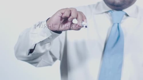 Adult Writes Viral Marketing on Clear Board