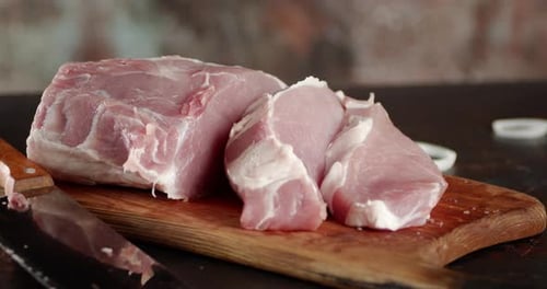 Sliced Raw Pork on a Cutting Board Rotates.