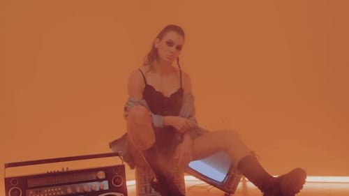 Young Woman Posing with Boombox and Television