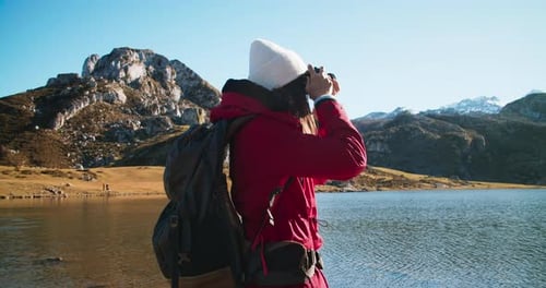 Portrait of Young Woman Travel Photographer Making Shot of Epic Mountain on Lake
