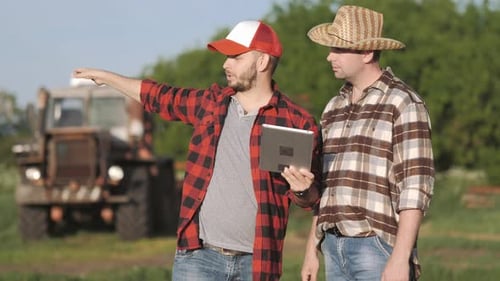 Farmers Discussing Tablet Data in a Rural Field