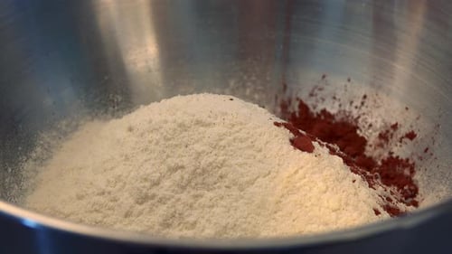 Cocoa Powder Being Poured Into Flour In Bowl