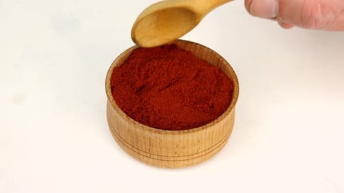 Red Pepper Spice Scooped from Wooden Bowl