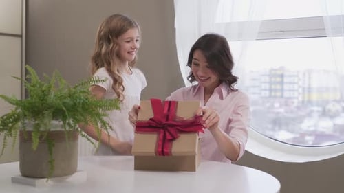 Child Surprises Mother with Birthday Gift at Home