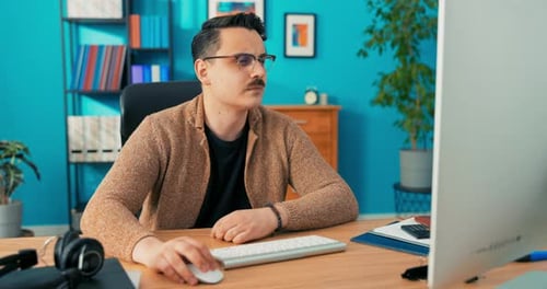 Konzentrierter junger Geschäftsmann sitzt am Schreibtisch Blick in die Kamera Seriöser männlicher professioneller Analyst