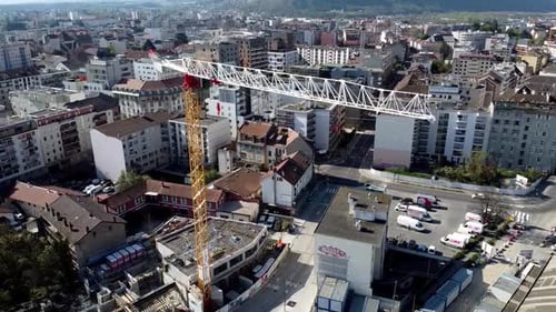 Disparo de una grúa en un sitio de construcción con un paisaje urbano detrás
