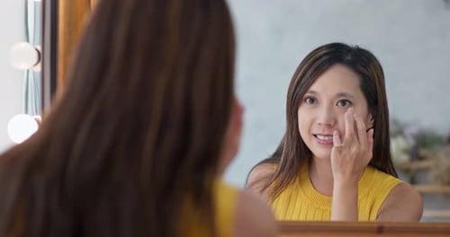 Woman use finger touch on her face in beauty make up studio