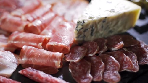 Assorted Deli Meats, Ham, Salami, Bacon and Tomatoes on the Black Stone Tray