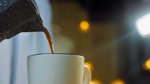 Coffee Being Poured Into Mug Close Up at Night