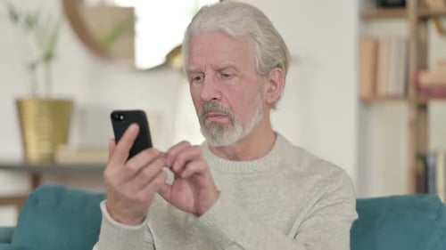 Senior Man Using Smartphone Indoors Close Up