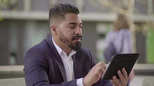 Man Works on Tablet in Urban Environment