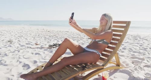Caucasian woman taking a selfie on the beach