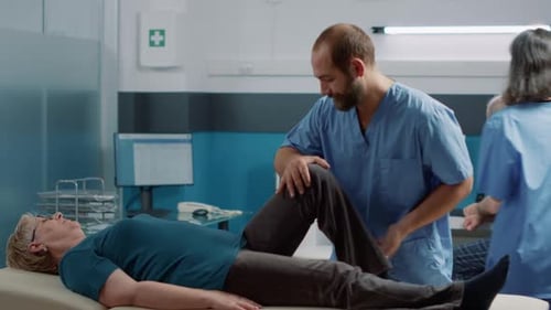 Physical Therapist Assists Senior Woman with Leg Exercise