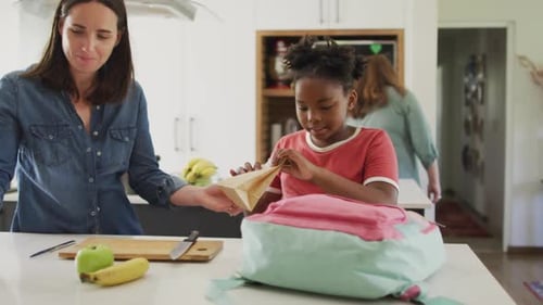 Mother Helping Child Packing School Bag at Home