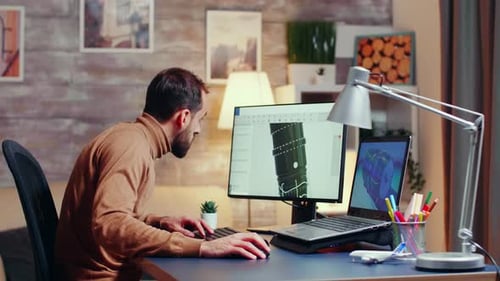Young Engineer Working Late at Night in His Home Office