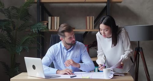 Businessmen and Asian Female Assistant in Formal Suits Meet in Office for Project Discussion