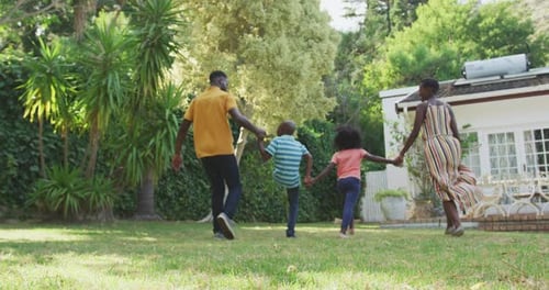 Happy Family Walking Together in Lush Backyard