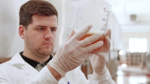 Un employé d'une brasserie examine le produit fini
