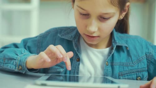 Little Girl Playing Online Games on Tablet