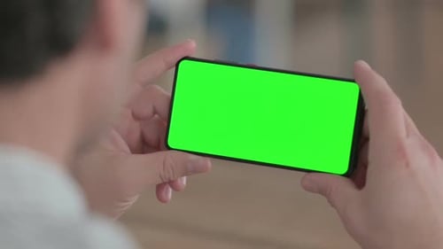 Adult Holding Phone with Green Screen Horizontally