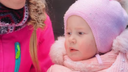 Mother Holding Baby in Winter Snow Scene