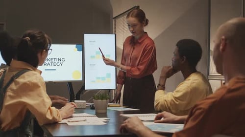 Jovem mulher fazendo apresentação para colegas da agência de marketing