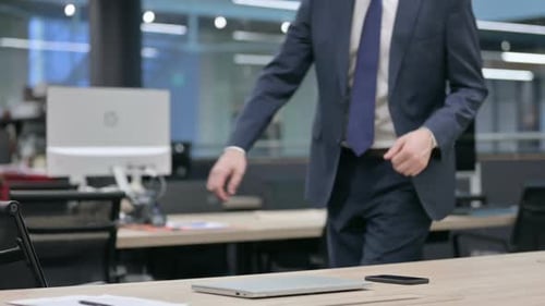 Businessman Coming Back Opening Laptop in Office