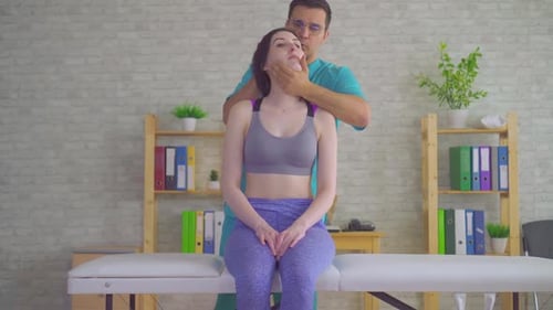 Männlicher chiropaktischer Massagetherapeut behandelt junge Patienten vor Nackenschmerzen
