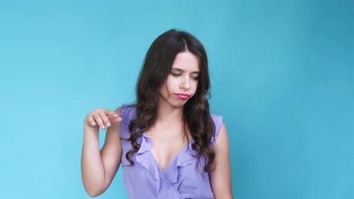Woman Waving Hand to Cool Off on Blue Backdrop