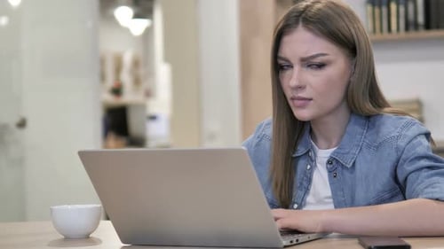 Woman Typing on Laptop at Desk Indoors