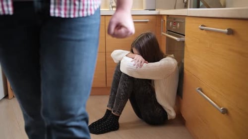 Distraught Girl Huddling as Man Clenches Fist