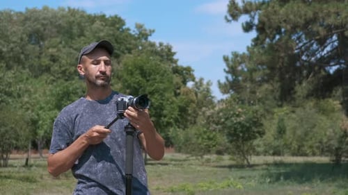 Photographer Sets Up Camera on Tripod in Park